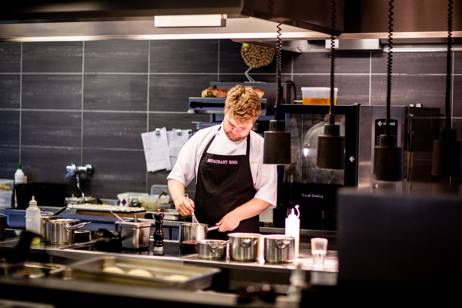 Private chef plating a gourmet dish in a home kitchen